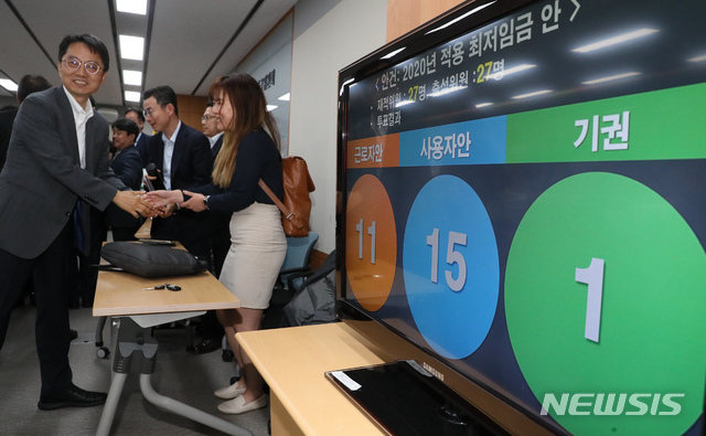 【세종=뉴시스】강종민 기자 = 12일 새벽 정부세종청사에서 열린 최저임금위원회 13차 전원회의에서 2020년 최저임금이 2.87% 인상된 8590원으로 결정됐다.&nbsp; 박준식 최임위원장이 관계자들과 악수하고 있다. 2019.07.12.&nbsp; ppkjm@newsis.com