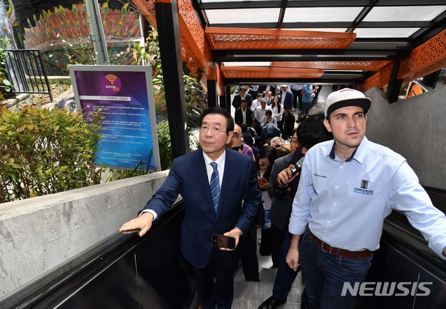 [서울=뉴시스]박원순 서울시장이 지난해 7월 콜롬비아 메데진 산비탈 빈민가 코무나13(Comuna13) 지역을 방문해 주민들의 이동편의를 위해 설치된 에스컬레이터를 타고 있다. (사진=뉴시스 DB). photo@newsis.com