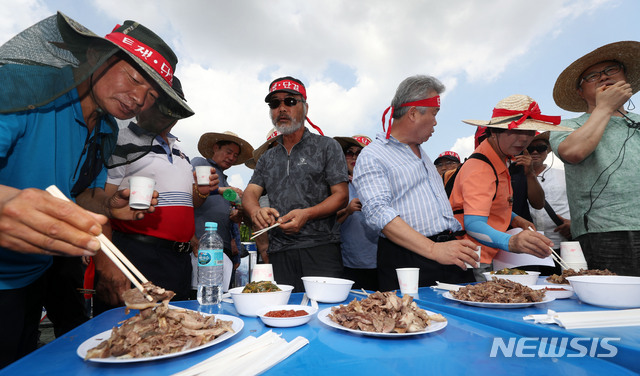 【서울=뉴시스】홍효식 기자 = 개 사육 농민 단체인 대한육견협회 회원들이 초복인 12일 서울 여의도 국회 앞에서 열린 기자회견에서 개 식용 금지 법안 반대를 주장하며 개고기 시식 퍼포먼스를 하고 있다. 2019.07.12.&nbsp; yesphoto@newsis.com