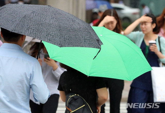 【서울=뉴시스】박주성 기자 = 서울에 소나기가 내린 지난 15일 오후 서울 광화문 사거리에 시민들이 우산을 쓰고 이동하고 있다. 2019.07.15. park7691@newsis.com