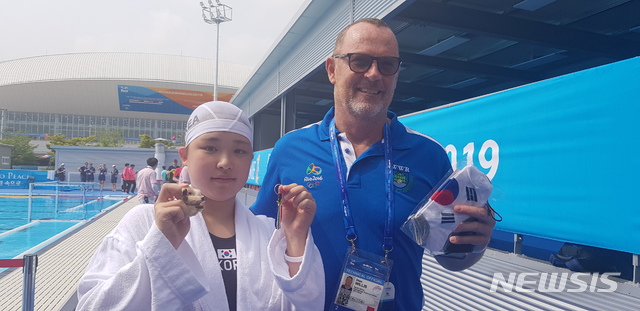 【광주=뉴시스】 김희준 기자 = 16일 오전 광주 광산구 남부대학교 수구경기장에서 열린 러시아와의 2019 광주세계수영선수권대회 여자 수구 조별예선 2차전에서 첫 골을 성공한 경다슬이 경기 후 남아프리카공화국 디온 윌리스 심판과 선물을 주고 받은 뒤 기념사진을 찍고 있다. 2019.07.16. bjko@newsis.com