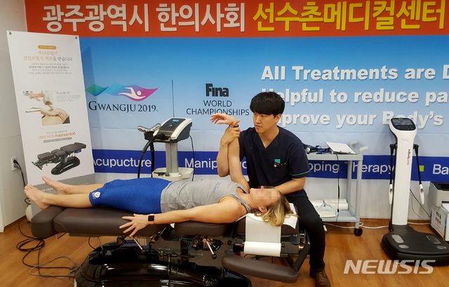 【광주=뉴시스】신대희 기자 = 16일 광주세계수영선수권대회 조직위원회에 따르면, 광주 광산구 우산동 선수촌의 문을 연 5일부터 15일까지 선수촌 메디컬센터 내원환자 779명 중 255명이 한의과 진료실을 찾았다. 사진은 한의사들이 각국 선수들을 진료하고 있는 모습. 2019.07.16. (사진 = 광주세계수영대회 선수촌 메디컬센터 한의과 진료실 제공) photo@newsis.com