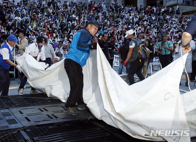 【서울=뉴시스】최동준 기자 = 우리공화당 관계자들이 16일 오전 서울 광화문광장 천막을 자진 철거한 뒤 세종문화회관 앞 인도에 설치했던 천막을 다시 자진 철거하고 있다. 2019.07.16. photocdj@newsis.com