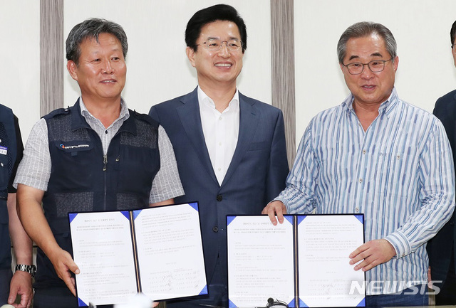 【대전=뉴시스】함형서 기자 =16일 오후 대전 시내버스 노사가 이틀간 마라톤협상 끝에 임금 인상률에 합의한 뒤 김희정 대전시지역버스노조 위원장(왼쪽), 김광철 대전시내버스운송사업조합 이사장(오른쪽), 허태정 대전시장(가운데) 이 기념사진을 찍고 있다.2019.7.16(사진=대전시청 제공)photo@newsis.com