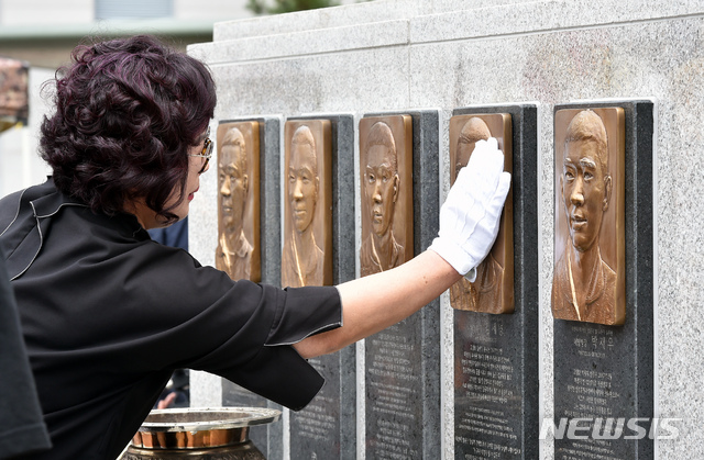 【포항=뉴시스】우종록 기자 = 17일 오전 경북 포항시 남구 오천읍 해병대 1사단 마린온 순직 장병 위령탑에서 열린 ‘마린온 순직자 1주기 추모행사’에서 헌화를 마친 유가족이 인물 부조를 어루만지고 있다. 2019.07.17.wjr@newsis.com