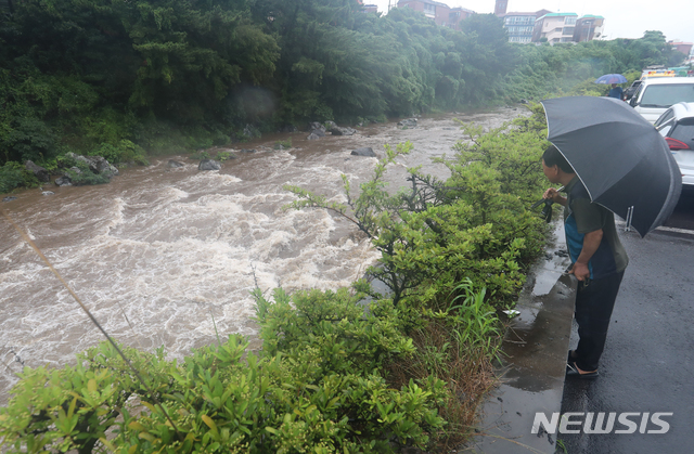 【제주=뉴시스】우장호 기자 = 제5호 태풍 '다나스(DANAS)'가 북상 중인 가운데 19일 오전 제주시 용담2동 한천에 주민들이 나와 걱정스러운 눈빛으로 빠른 물살을 바라보고 있다. 한천교 인근 지역은 지난 2007년 태풍 '나리' 내습 당시 범람해 많은 피해가 발생한 바 있다. 2019.07.19. woo1223@newsis.com
