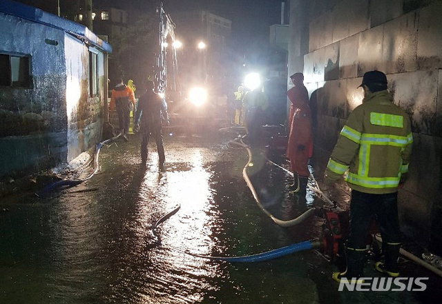 【제주=뉴시스】우장호 기자 = 제5호 태풍 '다나스(DANAS)'가 북상 중인 19일 제주시 건입동 김만덕기념관 인근 주택가에 빗물이 넘쳐 출동한 119가 배수작업을 하고 있다. 2019.07.19. (사진=제주소방서 제공)&nbsp; woo1223@newsis.com