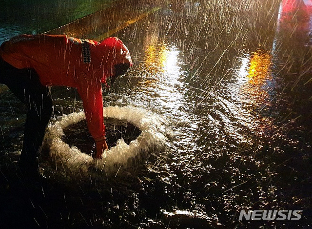 【제주=뉴시스】우장호 기자 = 제5호 태풍 '다나스(DANAS)'가 북상 중인 19일 제주시 도남동 인근 도로 상에서 하수 역류로 맨홀 뚜껑이 열려 출동한 119가 보수작업을 하고 있다. 2019.07.19. (사진=제주소방서 제공) woo1223@newsis.com