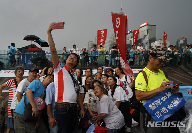 【홍콩=AP/뉴시스】20일 홍콩 입법회와 정부청사 건물이 있는 애드머럴티 지역에서 친중파 집회에 참석자들이 단체 사진을 찍고 있다. 최근 범죄인 인도 법(송환법)에 반대하는 시위에 맞서 공권력을 지지하고 질서 회복을 촉구하는 대규모 친중파 집회가 이날 열렸다. 2019.07.21 