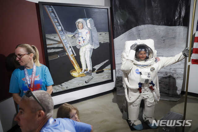 【와파코네타( 미 오하이오주)= AP/뉴시스】 오하이오주 와파코네타에 있는 암스트롱 항공우주 박물관을 찾은 탐방객들이 닐 암스트롱의 사진 등을 둘러보며 기념행사에 참가하고 있다.&nbsp;&nbsp; 