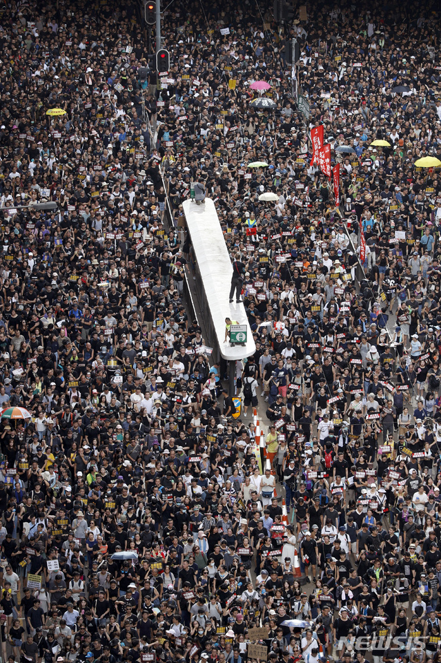 Protesters take part in a march on a street in Hong Kong, Sunday, July 21, 2019. Thousands of Hong Kong protesters marched from a public park to call for an independent investigation into police tactics. (AP Photo/Vincent Yu)
