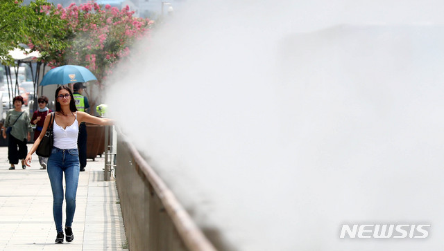 【서울=뉴시스】추상철 기자 =태풍이 물러가고 전국 대부분지방에 폭염주의보가 내려진 22일 오후 서울 종구 광화문광장에서 외국인 관광객이 가동된 쿨링포그에 무더위를 식히고 있다. 2019.07.22. scchoo@newsis.com