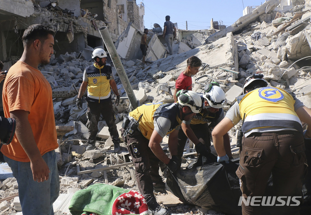 This photo provided by the Syrian Civil Defense White Helmets, which has been authenticated based on its contents and other AP reporting, shows Syrian White Helmet civil defense workers search for victims from under the rubble of a destroyed building that hit by Syrian government and Russian airstrikes, in the northern town of Maaret al-Numan, in Idlib province, Syria, Monday, July 22, 2019. Syrian opposition activists say an airstrike on a busy market in a rebel-held town in northwestern Syria has killed at least 16 people. (Syrian Civil Defense White Helmets via AP)