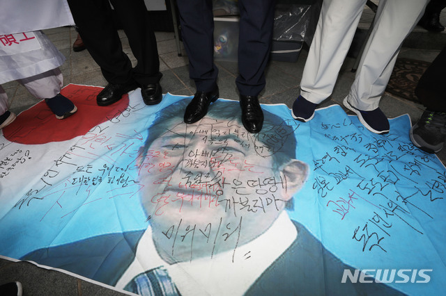 【서울=뉴시스】김진아 기자 = 독도사랑세계연대 관계자들이 23일 서울 종로구 옛 일본대사관 앞에서 열린 일본정부 규탄대회에서 일본의 경제 보복 조치를 규탄하며 아베 총리의 사진을 발로 밟고 있다. 2019.07.23. bluesoda@newsis.com