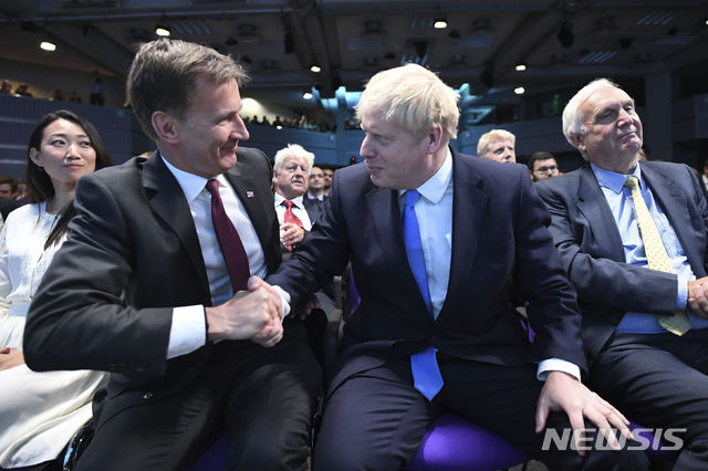 Jeremy Hunt, left, congratulates Boris Johnson after the announcement of the result in the ballot for the new Conservative party leader, in London, Tuesday, July 23, 2019. Brexit hardliner Boris Johnson won the contest to lead Britain's governing Conservative Party on Tuesday and will become the country's next prime minister, tasked with fulfilling his promise to lead the U.K. out of the European Union "come what may." (Stefan Rousseau/Pool photo via AP)