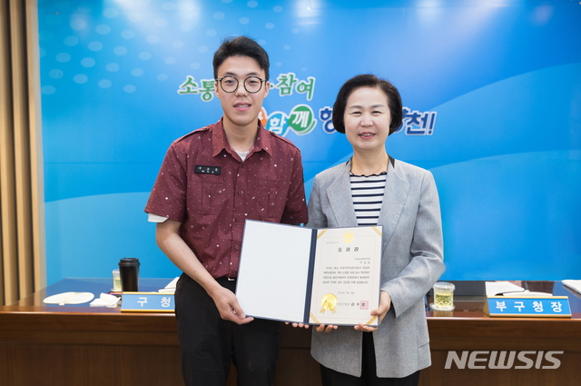 【서울=뉴시스】 사회복무요원 구교돈(왼)에게 표창을 수여 후 기념사진을 찍고 있는 김수영 양천구청장. 2019.07.24. (사진=양천구 제공)