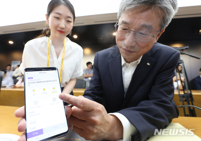 【서울=뉴시스】고승민 기자 = 24일 서울 여의도 KB국민은행 본점에서 열린 자영업자를 위한 모바일 플랫폼 '케이비 브릿지(KB Bridge)' 시연 및 간담회에서 허인 KB국민은행장이 어플리케이션을 시연하고 있다.케이비 브릿지는 자영업자가 자신의 상황에 맞춰 정부나 정책금융기관, 지자체 등 430여곳의 각종 지원 제도를 추천해주는 모바일 서비스로 인공지능 기술 활용이 특징. 2019.07.24.kkssmm99@newsis.com