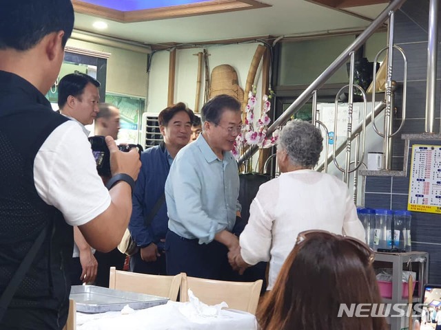 【서울=뉴시스】 문재인 대통령이 지난 주말 제주도를 방문한 것으로 29일 확인됐다. 청와대 등에 따르면 문 대통령은 26일 늦은 오후부터 28일까지 2박3일간 가족들과 함께 제주도를 비공식 방문했다. 사진은 문 대통령이 지난 27일 오전 현지 식당에서 식사를 하고 주민들과 인사를 나누는 모습. 2019.7.29.(사진 출처 : 제주특별자치도 소상공인경영지원센터 페이스북) 