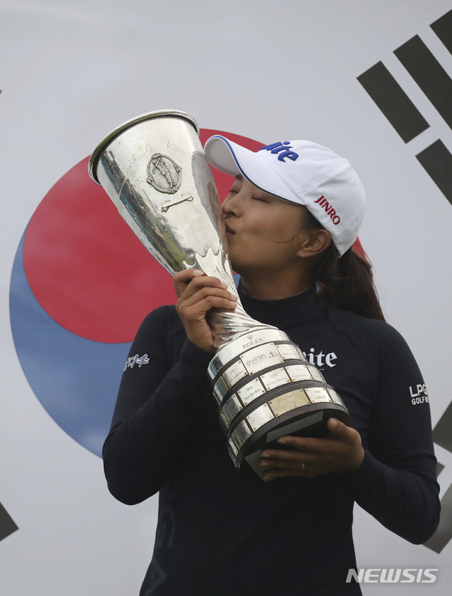 【에비앙레뱅(프랑스)=AP/뉴시스】고진영이 28일(현지시간) 프랑스 에비앙레뱅의 에비앙 리조트 골프클럽에서 막을 내린 시즌 네 번째 메이저 대회 LPGA 에비앙챔피언십에서 우승, 태극기 앞에서 트로피에 입 맞추고 있다.&nbsp; 고진영은 최종합계 15언더파 269타로 김효주 등 공동 2위 그룹을 2타 차로 따돌리고 미 여자프로골프(LPGA) 투어 통산 5승을 달성했다. 2019.07.29.