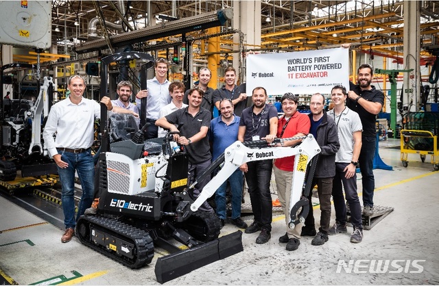 【서울=뉴시스】두산밥캣 직원들이 체코 도브리스 공장에서 생산된 E10e 양산 1호 제품과 함께 기념 사진을 촬영하고 있다. (사진=두산 제공)