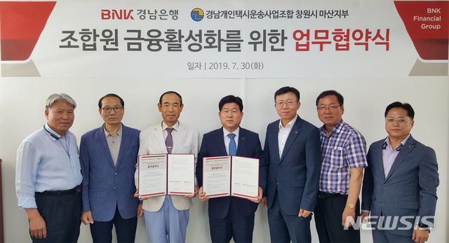 【창원=뉴시스】홍정명 기자= 30일 경남개인택시운송사업조합 창원시 마산지부 사무실에서 BNK경남은행 이창우(왼쪽 네 번째) 상무가 강신봉(왼쪽 세 번째) 마산지부장과 금융지원 업무협약을 체결한 뒤 관계자들과 기념촬영을 하고 있다.2019.07.30.(사진=BNK경남은행 제공) photo@newsis.com
