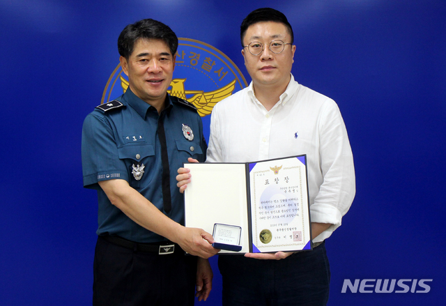 【광주=뉴시스】신대희 기자 = 지난 29일 광주 광산경찰서에서 이명호 광산경찰서장이 무안국제공항 특수경비대 국주영 대원에게 표창을 주고 있다. 국 대원은 세계수영선수권대회에 참여한 선수들을 몰래 촬영한 일본인 관객의 추가 범행을 밝히는 데 공을 세웠다. 2019.07.30. (사진 = 광산경찰 제공)photo@newsis.com