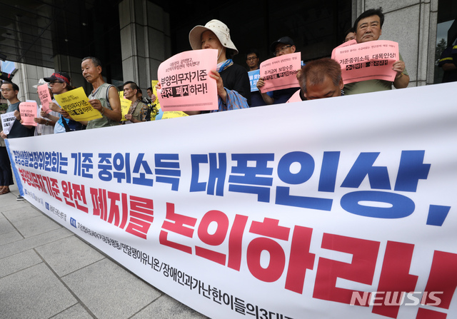 【서울=뉴시스】 이윤청 기자 = 장애인과가난한이들의3대적폐폐지공동행동, 민달팽이유니온 등 시민사회단체들이 30일 서울 중구 프레스센터 앞에서 기자회견을 열고 중앙생활보장위원회의 기준 중위소득 인상, 부양의무자기준 폐지를 촉구하고 있다. 2019.07.30.&nbsp;&nbsp; radiohead@newsis.com