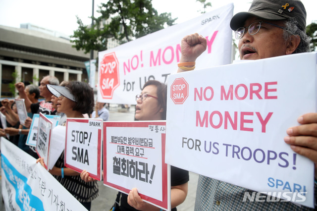 【서울=뉴시스】박미소 기자 = 평화와 통일을 여는 사람들 회원을 비롯한 시민단체 회원들이 31일 오전 서울 종로구 광화문 KT 앞에서 열린 '미국의 부당한 방위비분담금 대폭 증액 요구 규탄 기자회견' 에서 구호를 외치고 있다. 평화와 통일을 여는 사람들은 지난 24일 방한한 존 볼턴 미 백악관 국가안보회의 보좌관이 요구한 한미군 방위비분담금 증액 규모가 2019년 방위비분담금 1조 389억 원의 5.7배라고 비판하며 미국에 증액 요구를 철회할 것을 촉구했다.2019.07.31. misocamera@newsis.com