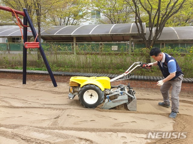 【서울=뉴시스】 동작구가 래미안상도3차아파트 어린이놀이터에서 이물질제거 및 평탄화작업을 하고 있는 모습. 2019.08.02. (사진=동작구 제공)