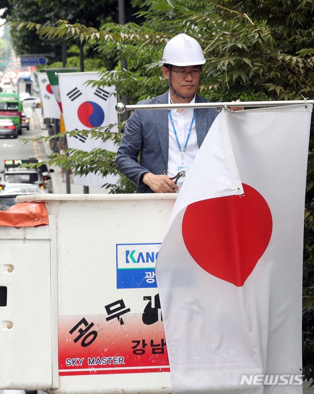 【서울=뉴시스】배훈식 기자 = 2일 오후 서울 강남구 테헤란로에서 구청 관계자가 일본정부의 '화이트리스트' 한국 제외 조치에 대한 항의 표시로 거리에 게양된 일장기를 철거하고 있다. 2019.08.02. photo@newsis.com