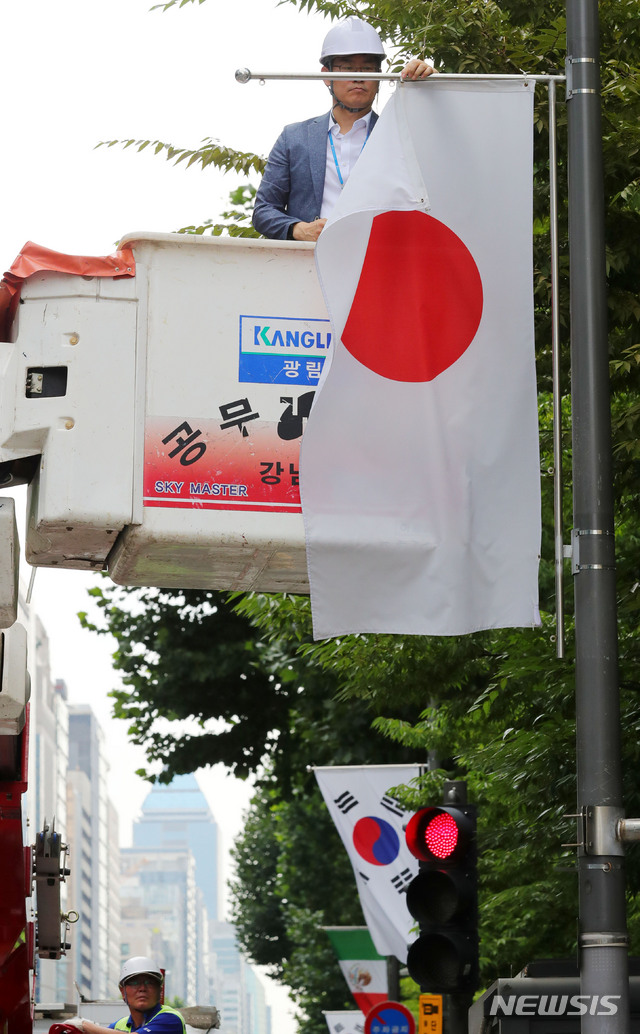 【서울=뉴시스】배훈식 기자 = 일본 정부가 수출절차 간소화 혜택을 인정하는 화이트리스트 명단에서 한국을 제외하는 수출무역관리령 개정안을 의결한 2일 오후 서울 강남구 테헤란로에서 구청 관계자가 이에 대한 항의 표시로 거리에 게양된 만국기 중 일장기를 철거하고 있다. 2019.08.02. dahora83@newsis.com