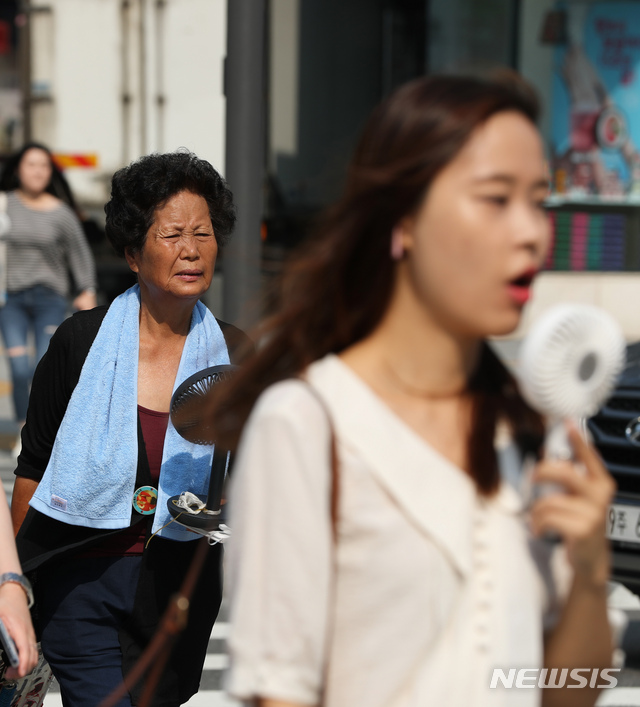 [서울=뉴시스] 이윤청 기자 = 전국 대부분 지역에 폭염경보가 발효되고 서울 낮 최고기온이 37도로 예보된 지난해 8월5일 오전 서울 광화문광장에서 시민들이 횡단보도를 건너고 있다. 2019.08.05. radiohead@newsis.com