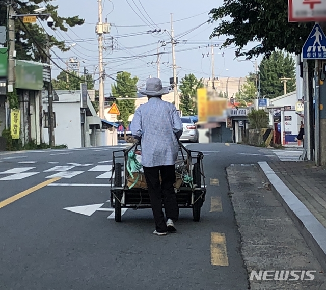 【대구=뉴시스】대구 주택가에서 한 노인이 폐지를 수집하기 위해 손수레를 끌며 걷고 있다. 뉴시스DB. 2024.06.16. photo@newsis.com