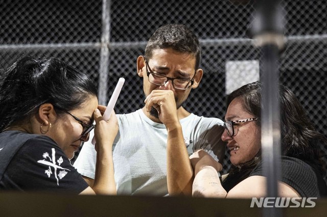 【엘패소=AP/뉴시스】지난 3일(현지시간) 미 텍사스주 엘패소 총기 난사 당시 사람들의 대피를 도운 3명의 월마트 직원이 4일 인근 공원에서 열린 희생자 추모 모임에서 감정이 격해져 울음을 터트리고 있다. 2019.08.06. 