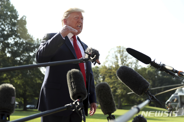 【워싱턴=AP/뉴시스】 도널드 트럼프 미 대통령이 7일 오전 최근의 총기난사 사고 도시인 데이턴과 앨패소 방문 차 마린원 탑승하기 직전 백악관 남쪽 정원에서 기자들의 질문에 답하고 있다. 3일과 4일 양 도시에서 모두 31명이 사망했으며 상당수 시민들은 트럼프의 방문을 달갑게 여기지 않고 있다. 2019. 8. 7.