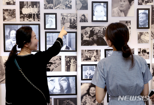 【서울=뉴시스】김병문 기자 = 8일 오후 서울 종로구 갤러리 이즈에서 열린 ‘할머니의 내일' 전시를 찾은 시민들이 위안부 피해자 할머니들의 사진을 보고 있다. 나눔의 집과 여성가족부가 주최한 이번 서울 전시는 금일부터 오는 19일까지 진행된다. 2019.08.08. dadazon@newsis.com