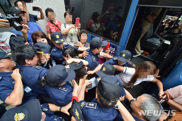 【제주=뉴시스】우장호 기자 = 12일 오전 제주지법에서 전 남편을 잔혹하게 살해한 뒤 시신을 훼손·유기한 혐의를 받는 고유정(36)의 첫 공판이 열린 가운데 시민들이 호송차에 오르는 고유정의 머리채를 잡아 당기고 있다. 2019.08.12. woo1223@newsis.com