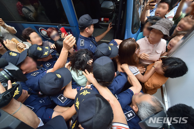 【제주=뉴시스】우장호 기자 = 12일 오전 제주지법에서 전 남편을 잔혹하게 살해한 뒤 시신을 훼손·유기한 혐의를 받는 고유정(36)의 첫 공판이 열린 가운데 시민들이 호송차에 오르는 고유정의 머리채를 잡아 당기고 있다.  2019.08.12. woo1223@newsis.com