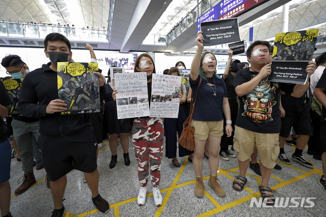 【홍콩=AP/뉴시스】12일(현지시간) 홍콩 국제공항 입국장에서 오른쪽 눈에 안대를 붙인 시위대가 경찰의 고무탄 발사로 한 여성이 실명한 것에 대해 항의하는 시위를 벌이고 있다. 지난 11일 홍콩 경찰이 고글을 착용한 한 여성 시위자에게 고무탄을 쏴 고글을 깨고 들어간 탄환이 여성을 실명시킨 것으로 전해진 바 있다. 2019.08.12.