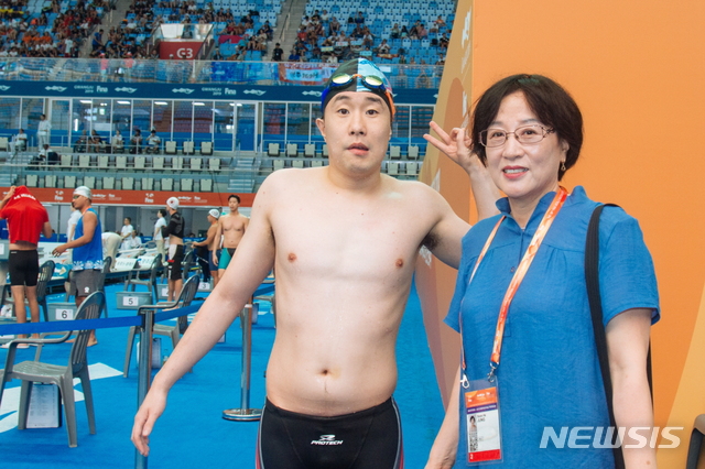 【광주=뉴시스】 송창헌 기자 = 자폐장애 1급 이동현(29)씨가 13일 광주 남부대 시립국제수영장 메인경기장에서 펼쳐진 세계마스터즈수영대회 남자 자유형 100m 경기를 마친 뒤 어머니와 기념사진을 찍고 있다. 이씨는 7명 중 3위를 차지했다. 2019.08.13 (사진=조직위 제공)photo@newsis.com
