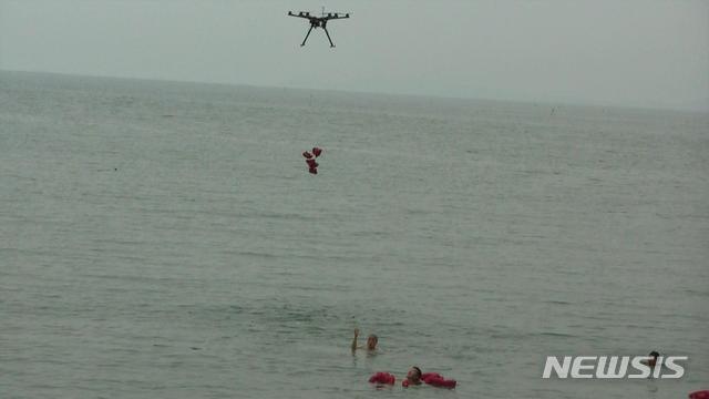 【서울=뉴시스】 한국항공대학교 항공우주 및 기계공학부 김병규 교수 연구팀이 개발한 인명구조드론이 주문진 해수욕장에서 이뤄진 해상실험에서 조난자 구조 작업을 펼치고 있다. (제공 = 한국항공대)