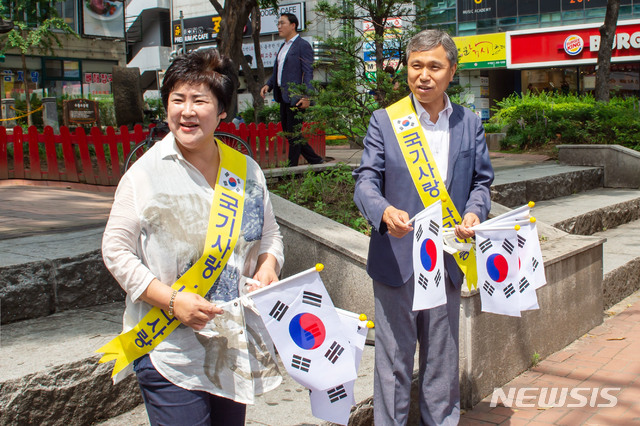   이건한 용인시의회 의장이 14일 시민들에게 태극기를 무료로 나누어 주고 있다. (사진제공=용인시의회)