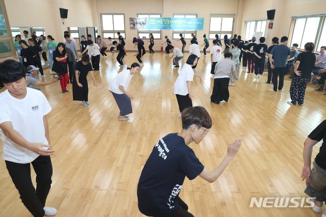 【고성(경남)=뉴시스】신정철 기자=경남 고성군 고성읍에 소재한 고성오광대전수관에는 14일, 불볕더위에도 고성탈놀이를 배우기 위해 전국에서 모여든 350여명의 젊은이들의 열정으로 활활 타오르고 있다. 고성오광대 여름탈놀이 배움터에 올해도 방학을 맞이한 한국예술종합대학생, 이화여대, 한양대, 서울예대, 고려대, 경주대 학생과 고성군내 초등학생들이 고성오광대 전수자 및 이수자들의 지도 아래 오광대 기본과정부터 과장교육, 판소리특강, 오광대 의상 및 소품착용법, 악기연주 등을 배우고 있다. 2019.08.14.(사진=고성군 제공)    photo@newsis.com