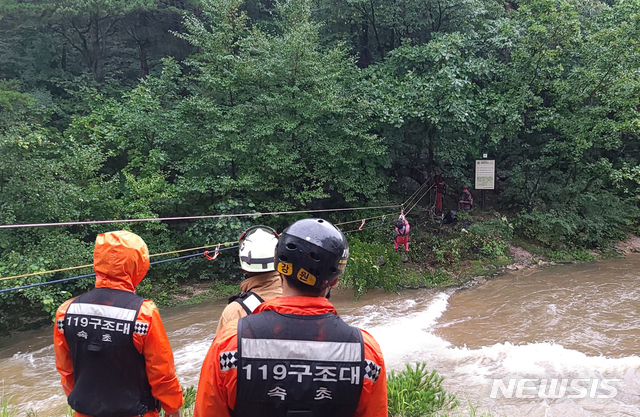 (사진은 15일 오전 11시 44분께 강원 고성군 토성면 원암리 미시령계곡에서 갑자기 불어난 불로 고립됐던 주민 2명이 119구조대에 의해 구조되고 있다)