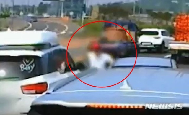 [제주=뉴시스]지난해 7월4일 제주시 조천읍한 도로 위에서 카니발 차량 운전자 A(34)씨가 주먹을 휘두르고 있다. (사진=유튜브 영상 캡처)
