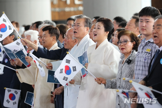 【천안=뉴시스】박진희 기자 = 문재인 대통령과 부인 김정숙 여사가 15일 충남 천안시 독립기념관에서 열린 제74회 광복절 경축식에서 참석자들과 함께 태극기를 흔들며 광복절 노래를 부르고 있다. 2019.08.15.   pak7130@newsis.com