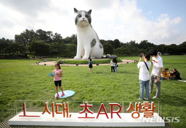 【서울=뉴시스】김선웅 기자 = 16일 서울 송파구 올림픽공원 88잔디마당 내에 SK텔레콤이 마련한 'AR 동물원'에서 증강현실(AR) 서비스를 즐기고 있다. 점프 AR동물원은 '점프 AR' 앱을 통해 자이언트 캣, 자이언트 비룡 등 거대 동물과 레서판다, 웰시코기 등 귀여운 미니 동물을 증강현실에서 만날 수 있는 서비스다. 통신사 상관없이 누구나 AR동물을 관람할 수 있다. 2019.08.16. mangusta@newsis.com