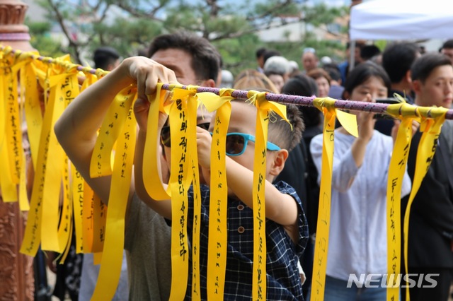 【청주=뉴시스】조성현 기자= 17일 오전 청주고인쇄박물관에 위치한 고(故) 민준영(당시 36세)·박종성 대원(당시 42세)의 추모 조형물 앞에서 유가족 등이 노란 리본을 달고 있다.jsh0128@newsis.com