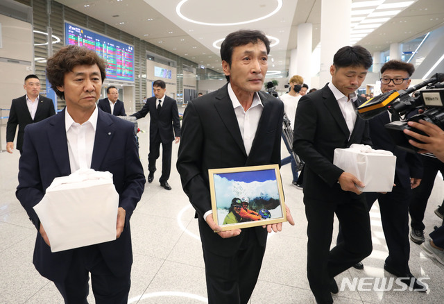 【인천공항=뉴시스】 김진아 기자 = 17일 인천국제공항에서 고(故) 박종성 대원의 형 종훈씨(왼쪽부터), 최인배 한국산악구조대 부대장, 고(故) 민준영 대원의 동생 규형씨가 10년 전 히말라야에 '직지루트'를 개척하려다 실종됐던 고(故) 민준영, 박종성 대원의 유골을 들고 귀국하고 있다. 2019.08.17.&nbsp; bluesoda@newsis.com
