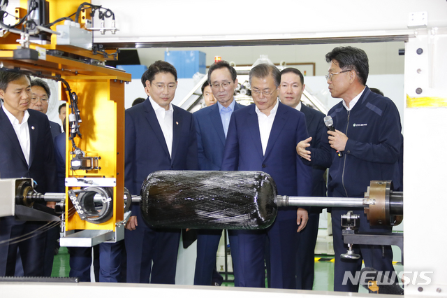 【전주=뉴시스】전신 기자 = 문재인 대통령이 20일 오후 전북 전주시 효성첨단소재㈜ 전주공장에서 열린 탄소섬유 신규투자 협약식이 끝난 뒤 탄소섬유가 플라스틱 저장용기를 감아서 성형하는 수소저장용기 제작 과정을 살펴보고 있다. 2019.08.20. photo1006@newsis.com